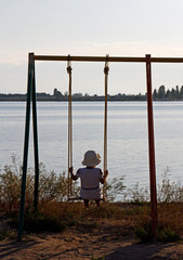 Girl on a swing in front of Lake Issyk Kul in Kyrgyzstan