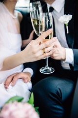 cropped view of bride and bridegroom clinking with champagne glasses