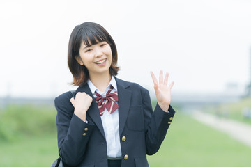 手を振る女子高生