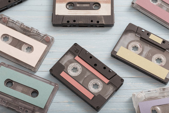 Old plastic cassette on wooden background. Retro music concept