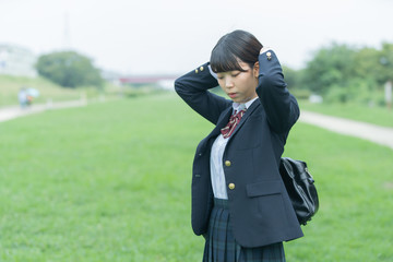 髪をまとめる女子高生