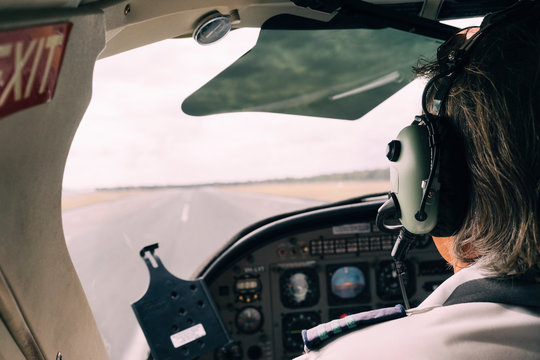 Pilot and dashboard of a small plane on the runway ready to take off