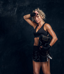 Fototapeta na wymiar Attractive blond woman feels tired after long hard boxing match.