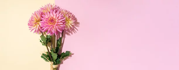 Fototapeten Festlicher Blumenstrauß über pastellrosa und gelbem Hintergrund, Kopierraum. Ansicht von oben. Kreative Grußkarte mit Dahlienblumen. Banner © jchizhe