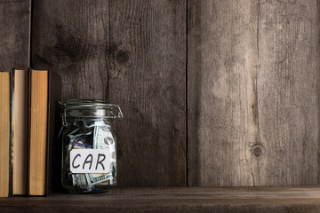 Bank with money on the old wooden bookshelf.