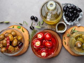 Italian food background, with bell peppers and green olives, stuffed with cheese, black olives, olive oil on wooden background.