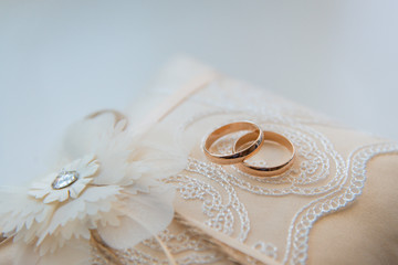 Two golden wedding rings on a lace pad © SergeyCash