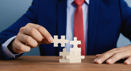 A businessman is assembling a puzzle; business concept