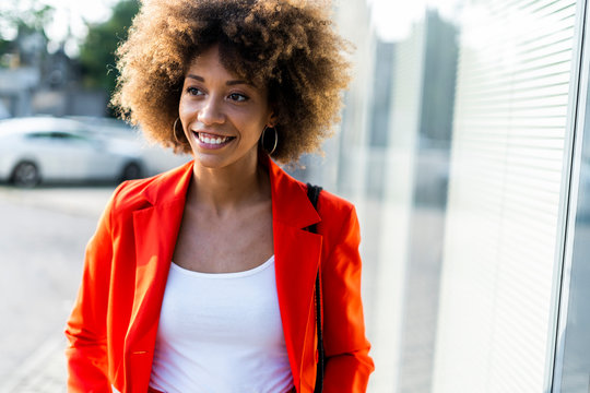 Portrait Of Smiling Young Woman Wearing Fashionable Red Suit Jacket