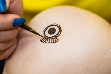 Drawing process of henna mehndi ornament on womans head