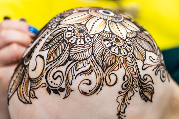 Drawing process of henna mehndi ornament on womans head