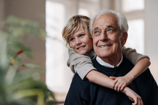 Happy Grandson Embracing Grandfather At Home