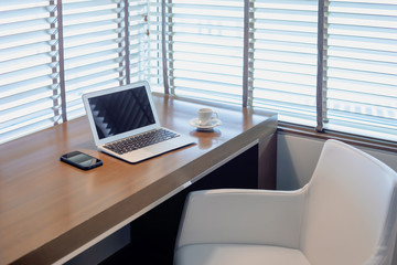 Modern workspace with laptop computer, smartphone and coffee cup