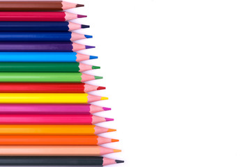 Colored sharpened wooden pencils lie on a white sheet of paper for creativity, drawing, notes, texts and letters
