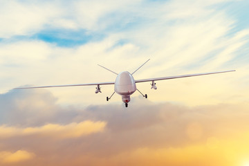 Unmanned military drone patrols the territory at sunset. The view is straight ahead.