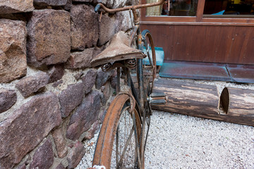 old rusty bicycle in front of a rock wall