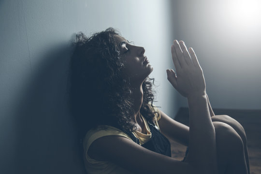 sad prayer woman in home
