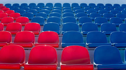 Bleachers in a sports stadium. Red and blue seats in a large street stadium.