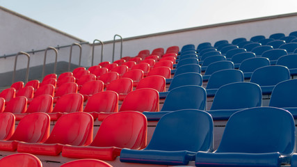 Bleachers in a sports stadium. Red and blue seats in a large street stadium.