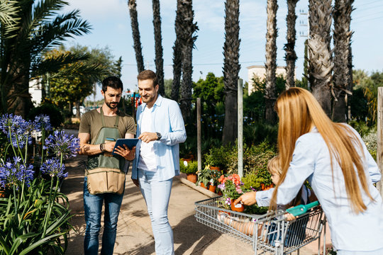 Worker with tablet in a garden center advising customer