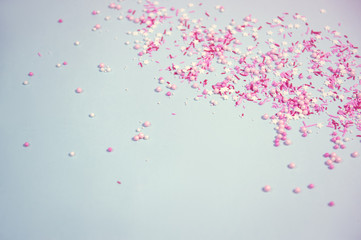 Colorful sprinkles on blue background, top view with copy space