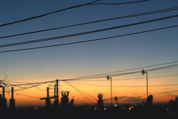 Telephone cables, chimneys and TV antennas silhouetted against the early morning sky just a few minutes before sunrise.