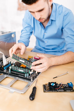 Technician repairing a desktop computer, changing the computer's RAM