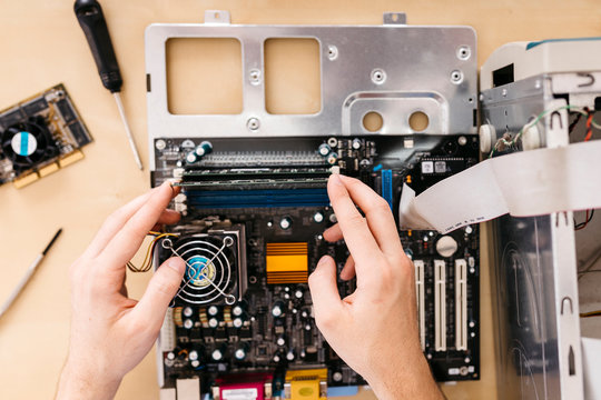 Close-up of technician repairing a desktop computer, changing the computer's RAM