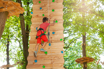 Boy rock climb high in the rope adventure park