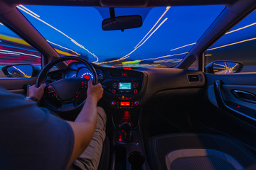 Night road view from inside car natural light street and other cars is motion blurred