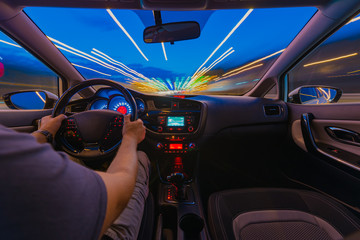 Night road view from inside car natural light street and other cars is motion blurred