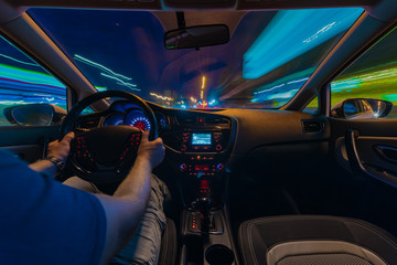 Night road view from inside car natural light street and other cars is motion blurred