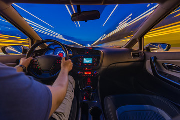 Night road view from inside car natural light street and other cars is motion blurred