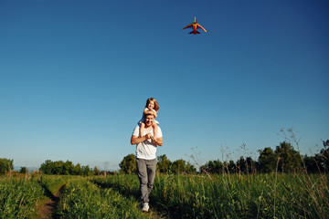 A father and child on meadow with a kite in the summer