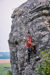 Young fit beautiful woman rock climbing in nature Slovakia