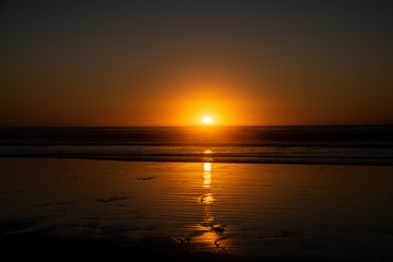 Fototapeta na wymiar Last sunlight of the day with sunset over the Atlantic Ocean from Agadir beach, Morocco, Africa