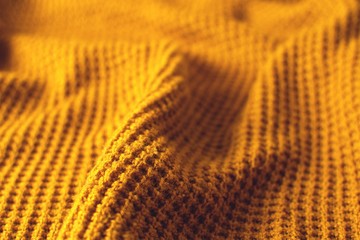 Mustard colored woollen sweater. Texture detail.