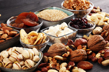Composition with dried fruits and assorted healthy nuts on rustic background
