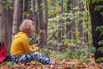 Young woman sitting in forest, relax in nature, woman check mail