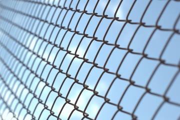 Wire fence against a clear blue sky, as concept for imprisonment, jail, sentence, etc.
