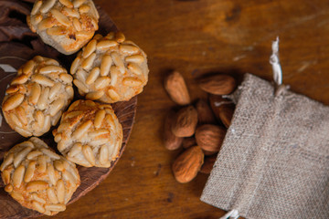 Closeup plate with Catalan panellets and some roasted almonds on a wooden table. Typical desert in Catalonia for Halloween (La Castanyada)