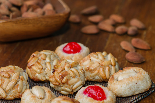 Closeup plate with Catalan panellets and some roasted almonds on a wooden table. Typical desert in Catalonia for Halloween (La Castanyada)