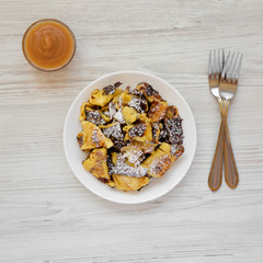 Homemade german Kaiserschmarrn pancake with apple sauce on a white wooden background, top view. Flat lay, overhead, from above. Close-up.