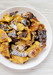 Homemade german Kaiserschmarrn pancake on a white wooden surface, top view. Flat lay, overhead, from above. Close-up.