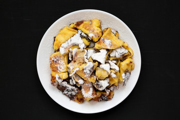 Homemade german Kaiserschmarrn pancake with apple sauce on a black background, top view. Flat lay,...