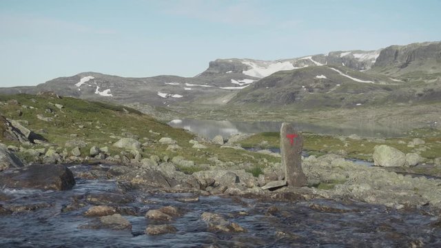 Glacial meltwater river flowing from Hardanger Glacier, Norway hiking trail, still shot