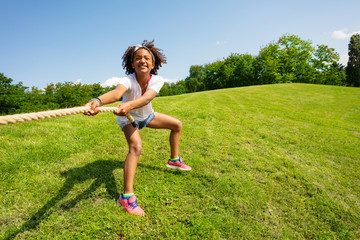 Cute looking young black curly girl pull rope