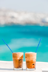 Coffee latte on wooden table with sea background