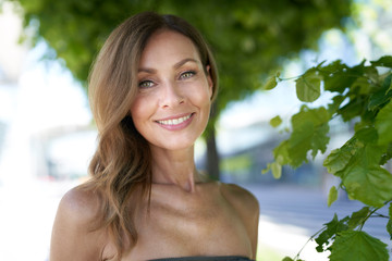 Portrait of mature woman, tree in the background