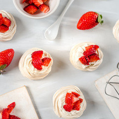 Homemade small strawberry pavlova meringue cakes pattern with cream top view